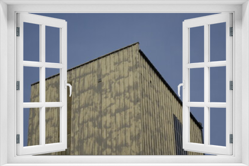 Fototapeta Naklejka Na Ścianę Okno 3D - Cubic metal tower of factory building under blue spring sky, concept: industry, industrial (horizontal), Seltz, Grand Est, France