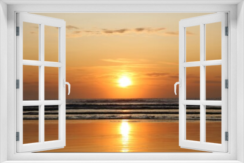 Fototapeta Naklejka Na Ścianę Okno 3D - Sunrise on the beach. Vibrant colors of the sun, reflections in the water and sand. Beautiful scenery of nature. Red sky, rising sun, lots of light in the ocean waters. Magnificent marine sunset scene