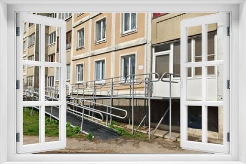 Fototapeta Naklejka Na Ścianę Okno 3D - A ramp with metal railings is installed to enter a residential building for people with disabilities in wheelchairs. This creates a barrier-free environment