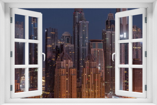 Fototapeta Naklejka Na Ścianę Okno 3D - Skyscrapers of Dubai Marina near intersection on Sheikh Zayed Road with highest residential buildings night to day timelapse