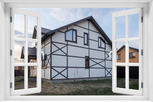 Fototapeta Naklejka Na Ścianę Okno 3D - End of construction. The house is built on a plot surrounded by other houses. Houses in different styles