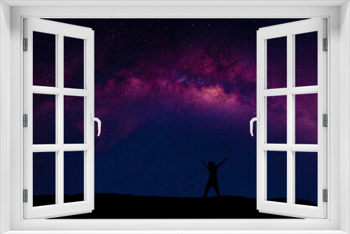 Fototapeta Naklejka Na Ścianę Okno 3D - A person standing happily beside the Milky Way Galaxy pointing to a bright star.