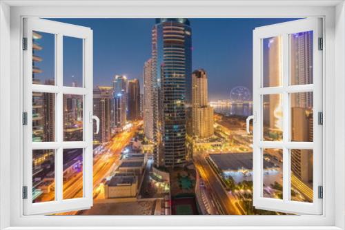 Fototapeta Naklejka Na Ścianę Okno 3D - Panoramic view of the Dubai Marina and JBR area and the famous Ferris Wheel aerial night to day timelapse