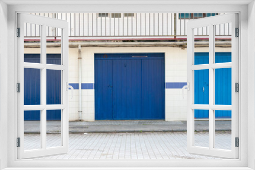 Fototapeta Naklejka Na Ścianę Okno 3D - Puertas de garage en diferentes tono de azul en calle