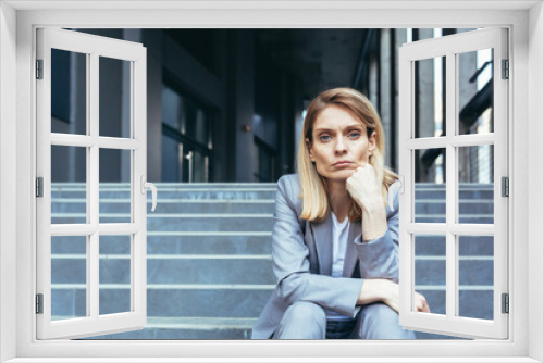 Close-up portrait of sad upset business woman sitting tired on stairs of office building