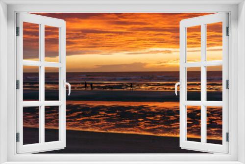 Fototapeta Naklejka Na Ścianę Okno 3D - Beautiful sunset with dramatic moody cloudy sky above the ocean of North Sea and silhouette of people and dogs, De Haan, Belgium.
