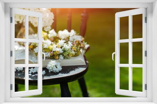 Fototapeta Naklejka Na Ścianę Okno 3D - książka, wianek i bukiet białego bzu jako kompozycja na starym krześle w słonecznym ogrodzie