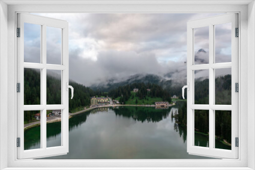 Fototapeta Naklejka Na Ścianę Okno 3D - Panorama drone view of Lago di Misurina, reflection of the mountain in the lake, flying through the fog in the Dolomites in Italy