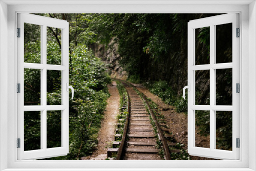 Fototapeta Naklejka Na Ścianę Okno 3D - Fairy-tale landscape of abandoned rails laid along high mountains. Summer forest after the rain.