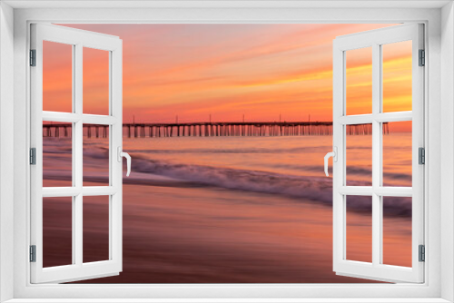 Fototapeta Naklejka Na Ścianę Okno 3D - dramatic pastel colors of the summer morning sky as the waves of the Atlantic waters rush in the shores and pier of Virginia Beach.