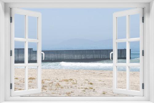 Fototapeta Naklejka Na Ścianę Okno 3D - The border fence between the U.S. and Mexico viewed from the beach at the Border Field State Park in San Diego, California. It separates San Diego from Tijuana and extends into the Pacific Ocean.