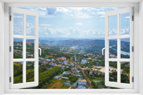 Fototapeta Naklejka Na Ścianę Okno 3D - Aerial view of National Route 14 in Kien Duc town, Dac Nong province, Vietnam with hilly landscape and sparse population around the roads.