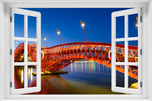 Fototapeta Naklejka Na Ścianę Okno 3D - A bridge in the city at night. The bridge against the sky during the blue hour. The Python Bridge, Amsterdam, the Netherlands. Panoramic photography for design and background..