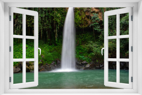 Fototapeta Naklejka Na Ścianę Okno 3D - Waterfall scenery background surrounded by greenery in the forest