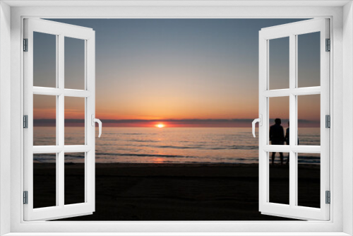 Fototapeta Naklejka Na Ścianę Okno 3D - Two people, man and woman, watch the sunrise at the ocean