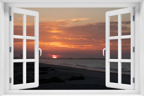 Fototapeta Naklejka Na Ścianę Okno 3D - The Sun rises over the Cape May National Wildlife refuge as seen from the beach in cape may New Jersey