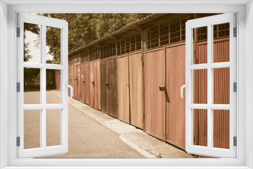 Fototapeta Naklejka Na Ścianę Okno 3D - Old rusty garages in a row with rust and striped doors