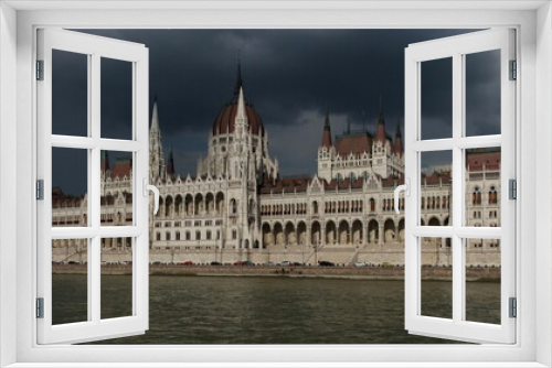 Parliament in Budapest viewed across the river Danube. Dark sky, heavy clouds.