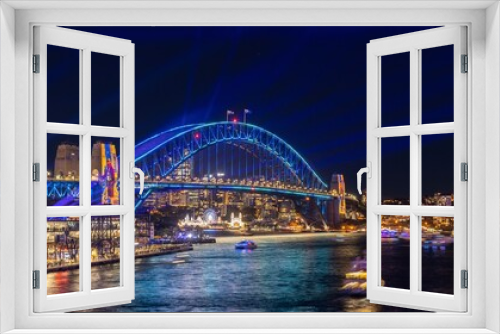 Fototapeta Naklejka Na Ścianę Okno 3D - Colourful Light show at night on Sydney Harbour NSW Australia. The bridge illuminated with lasers and neon coloured lights 