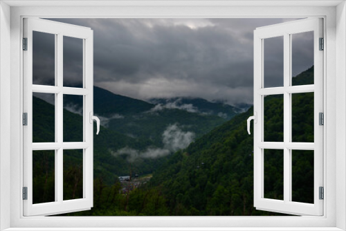 Fototapeta Naklejka Na Ścianę Okno 3D - Spring morning at mountains and clouds. Atmospheric landscape with trees and low clouds on cloudy sky. Awesome mountain scenery.