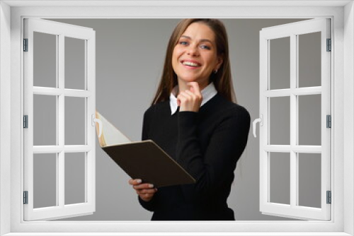 Happy woman teacher or student in black business suit holding book, isolated female portrait.