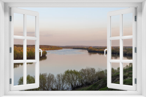 Fototapeta Naklejka Na Ścianę Okno 3D - Evening landscape. Cloudy May day. Clouds are reflected in the lake. Peaceful landscape on the banks of the reservoir. Relax in nature.