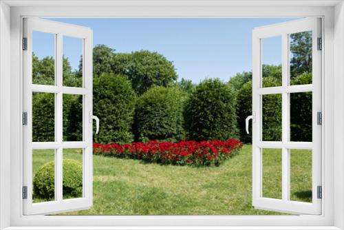 Fototapeta Naklejka Na Ścianę Okno 3D - garden with trees and red flowers