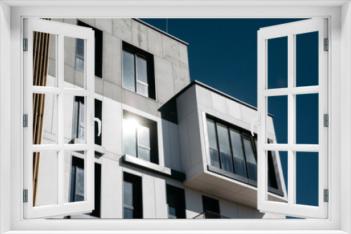 Fototapeta Naklejka Na Ścianę Okno 3D - Modern apartment buildings Facade with a blue sky. Glass surface with sunlight.