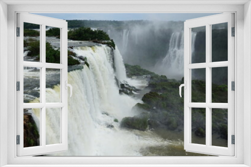 Fototapeta Naklejka Na Ścianę Okno 3D - The photo shows a stunning view from the top of the Iguazu Falls — a complex of 275 waterfalls on the Iguazu River, located on the border of Brazil and Argentina.