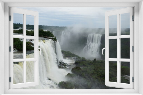 Fototapeta Naklejka Na Ścianę Okno 3D - The photo shows a stunning view from the top of the Iguazu Falls — a complex of 275 waterfalls on the Iguazu River, located on the border of Brazil and Argentina.