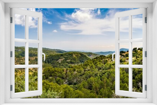Fototapeta Naklejka Na Ścianę Okno 3D - Panorama of the valley of the mountain village Galilea at Mallorca in the municipality of Puigpunyent surrounded by mountains, mediterranean forest and olive groves with view to the mediterranean sea.