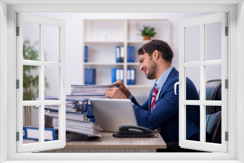 Young male employee and too much work in the office