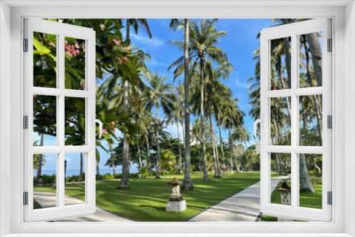 Fototapeta Naklejka Na Ścianę Okno 3D - Senggigi Beach West Nusa Tenggara, Indonesia December 14, 2021: Two paths that divide between the dense coconut trees on the beach