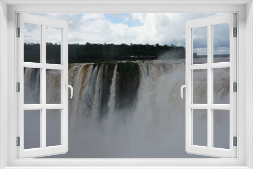 Fototapeta Naklejka Na Ścianę Okno 3D - The photo shows a stunning view from the top of the Iguazu Falls — a complex of 275 waterfalls on the Iguazu River, located on the border of Brazil and Argentina