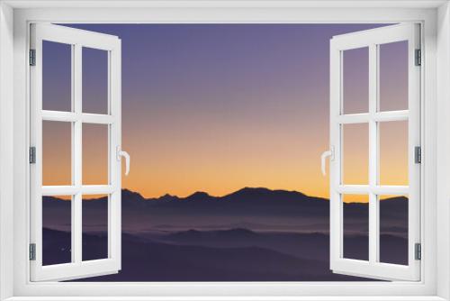 Fototapeta Naklejka Na Ścianę Okno 3D - Tramonto viola e arancio sui monti le valli e le colline