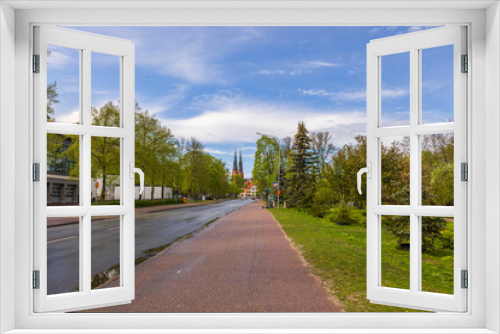 Fototapeta Naklejka Na Ścianę Okno 3D - Cityscape view of road with green trees on sides and famous church towers on background. Sweden. 