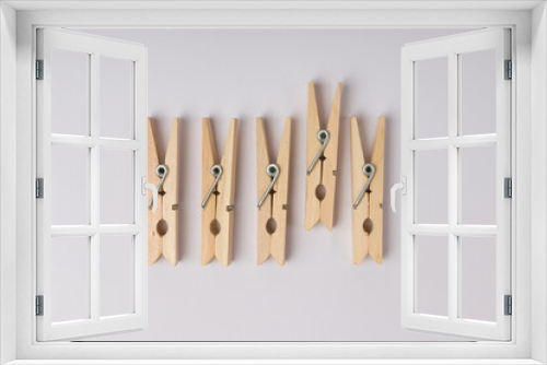 Fototapeta Naklejka Na Ścianę Okno 3D - wooden clothespins lie in a row on a white background