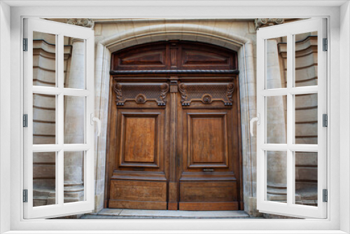 Elegant wooden door on a facade in French Bordeaux city