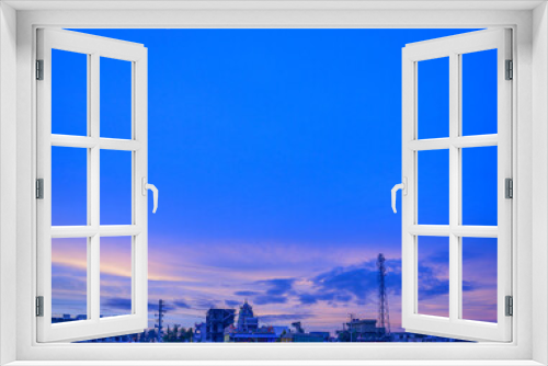 Fototapeta Naklejka Na Ścianę Okno 3D - Sunrise over a India against a striking blue sky with random buildings in the background. Can be used as a presentation slide.