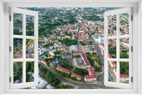 Fototapeta Naklejka Na Ścianę Okno 3D - aerial panoramic view from great height on red roofs of old big city with skyscrapers and white fluffy clouds