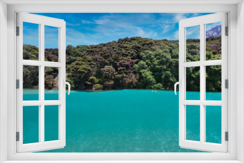 Fototapeta Naklejka Na Ścianę Okno 3D - Split shot of under and above the water looking at a lush tropical forest at the Bay of Islands area in New Zealand. Amazing turquoise-colored water in a beautiful travel destination. 