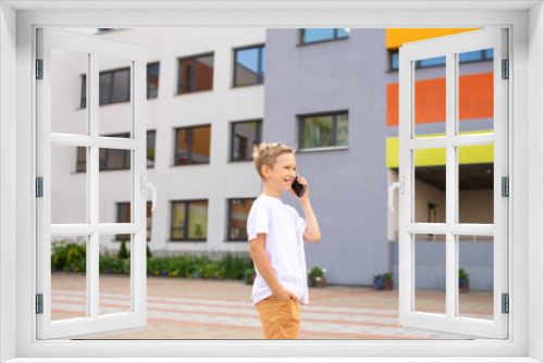 A child holds a phone in his hands near the school