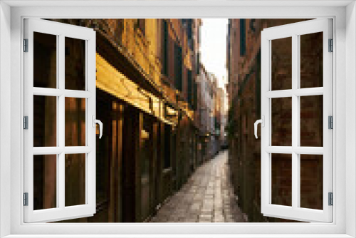 Fototapeta Naklejka Na Ścianę Okno 3D - Empty dark narrow cobbled street in Venice, Italy