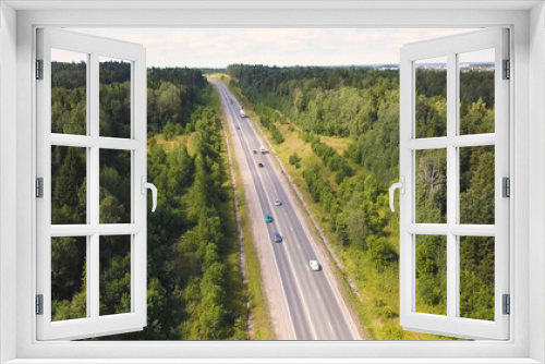 Fototapeta Naklejka Na Ścianę Okno 3D - Aerial view of car driving through the forest on country road. Cip. Cars Driving Through Forest Road Drone Travel Countryside Adventure. Aerial view flying over old patched two lane forest road with
