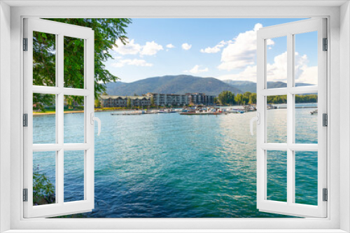 Fototapeta Naklejka Na Ścianę Okno 3D - View from the Sandpoint City Beach Park of Lake Pend Oreille waterfront resorts and condominiums with marinas full of boats on a summer day in Sandpoint, Idaho.