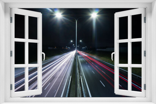 Fototapeta Naklejka Na Ścianę Okno 3D - night view of the highway, visible flares of street lamps, streaks of car lights