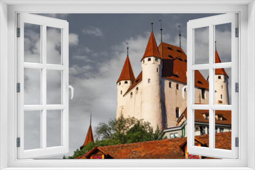 Fototapeta Naklejka Na Ścianę Okno 3D - Panoramic view of the white building with a brown tiled roof of the Thun castle, seen from below