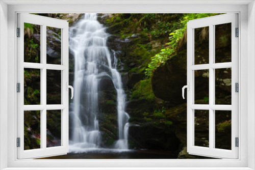 Fototapeta Naklejka Na Ścianę Okno 3D - Scenic, sunlit waterfall in the forest cascading down the moss covered cliff