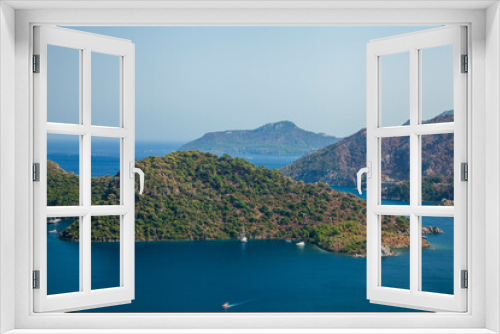 Fototapeta Naklejka Na Ścianę Okno 3D - Marmaris, Turkey – Beautiful view of the islands and the boats on the crystal clear water of the bay at sunny day with its misty green mountains at background and the blue bay.