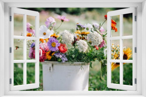 Fototapeta Naklejka Na Ścianę Okno 3D - bunter Blumenstrauß, Strauß mit Blumen in einem rustikalen Behälter auf dem Feld